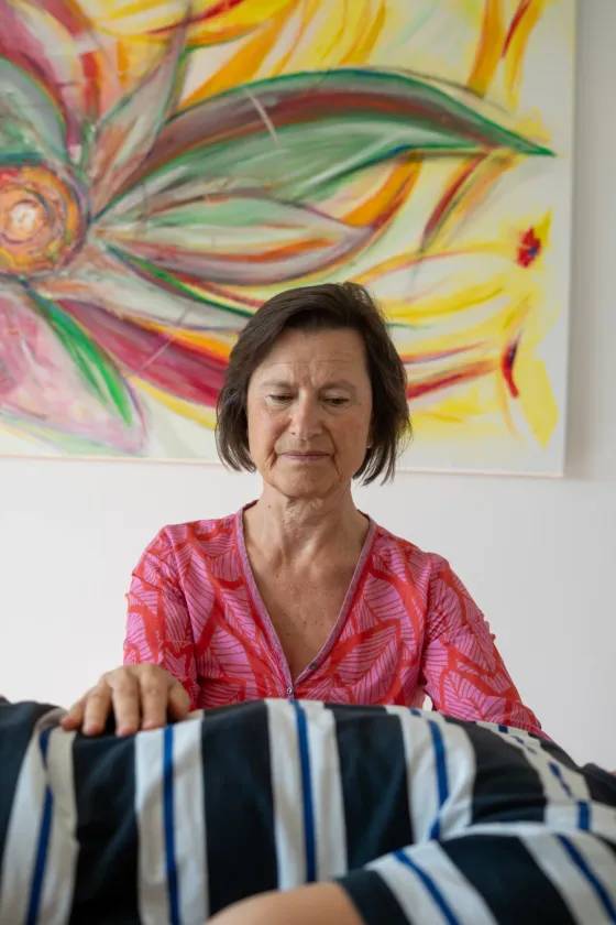Lisa Kellenberger mit geschlossenen Augen, die Hände ruhen auf einem liegenden Klienten
