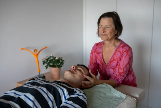 Lisa Kellenberger lächelt, während sie den Kopf einer liegenden Person hält